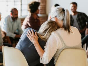 two people embracing one another during a support group